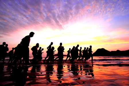 group of young people runs at the beachの写真素材