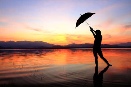 silhouette of young woman against summer sunsetの写真素材