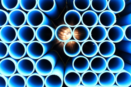 blue pipes stacked in construction site, pattern closeupの写真素材