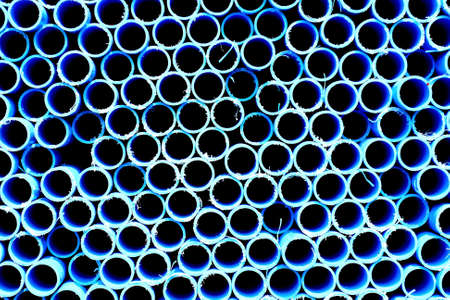 blue pipes stacked in construction site, pattern closeupの写真素材