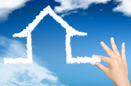 The House in the hands against the blue skyの写真素材