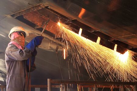 a welder working a torch at shipyardの写真素材