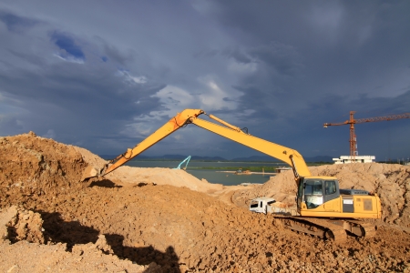 excavator loader machine during earthmoving works outdoors at construction siteの写真素材