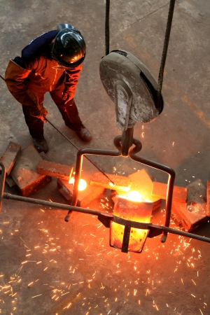 Pouring Molten Metal into Mold - focus on pourの写真素材