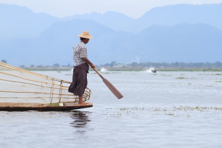 INLE LAKE, MYANMAR - NOVEMBER 18 : Fisherman catches fish for food on NOVEMBER 18, 2012 on Inle Lake, Myanmar. Intha people possess the leg-rowing style and the unique coop-like fishing equipmentのeditorial素材