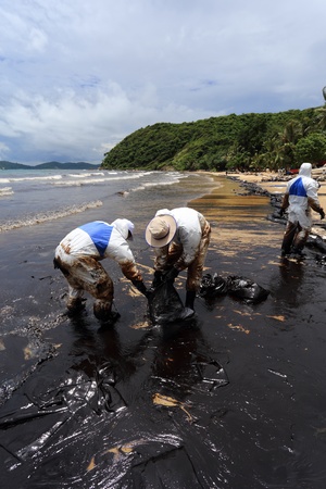 Ko Samet,THAILAND-July 31:Royal Thai Navy personel,and local volunteers clean up a beach from a major oil slick on Ao Phrao beach on the island of Ko Samet on July 31,2013 in Ko Samet island ,Rayong, Thailandのeditorial素材