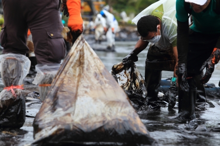 Ko Samet,THAILAND-July 31:Royal Thai Navy personel,and local volunteers clean up a beach from a major oil slick on Ao Phrao beach on the island of Ko Samet on July 31,2013 in Ko Samet island ,Rayong, Thailandのeditorial素材