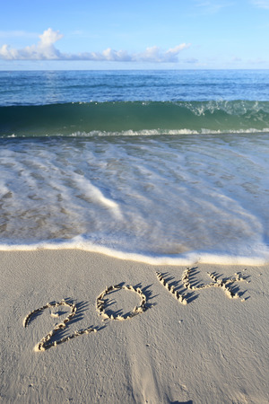 Year 2014 written in sand, on tropical beach