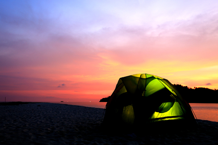 green tent on beach in sunsetの写真素材