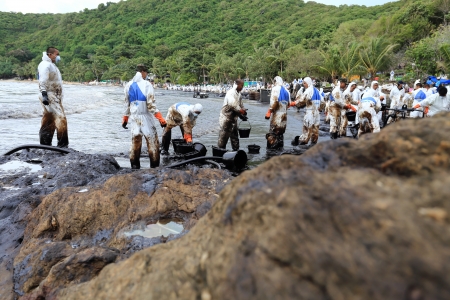 Ko Samet,THAILAND-July 31:Royal Thai Navy personel,and local volunteers clean up a beach from a major oil slick on Ao Phrao beach on the island of Ko Samet on July 31,2013 in Ko Samet island ,Rayong, Thailandのeditorial素材