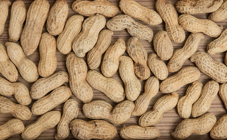 peanuts in shells over wood background