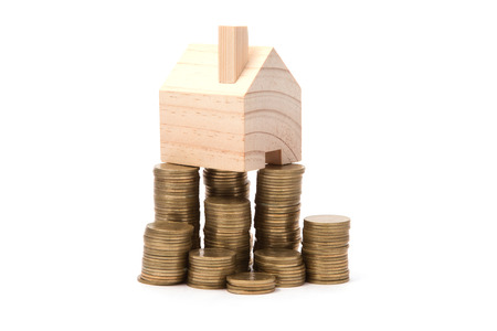 house standing on a heap of coinsの写真素材