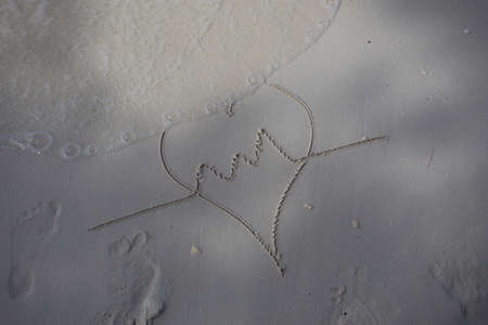 hearts drawn on the sand of a beachの写真素材