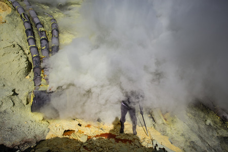 KAWAH IJEN, INDONESIA - OCT 12: Worker at sulfur mine inside Ijen crater on October 12, 2015. Miners are extracting gaseous sulfur going out in the mine of the craterのeditorial素材