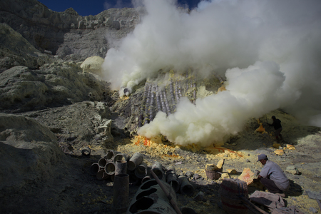 KAWAH IJEN, INDONESIA - OCT 12: Worker at sulfur mine inside Ijen crater on October 12, 2015. Miners are extracting gaseous sulfur going out in the mine of the craterのeditorial素材