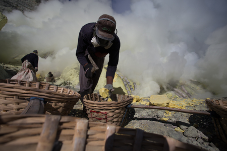 KAWAH IJEN, INDONESIA - OCT 12: Worker at sulfur mine inside Ijen crater on October 12, 2015. Miners are extracting gaseous sulfur going out in the mine of the craterのeditorial素材