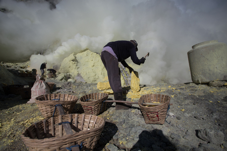 KAWAH IJEN, INDONESIA - OCT 12: Worker at sulfur mine inside Ijen crater on October 12, 2015. Miners are extracting gaseous sulfur going out in the mine of the craterのeditorial素材