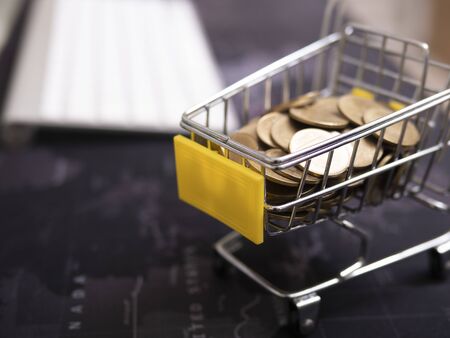 Shopping Cart With Coin On A Laptop Keyboard.