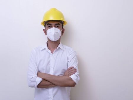 Asian industrial workers wear yellow hard hats, wear protective masks for their healthの写真素材
