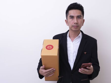 Shipper young Asian man holding cardboard boxの写真素材