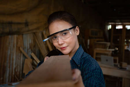 pretty hardworking carpenter woman at workplaceの写真素材