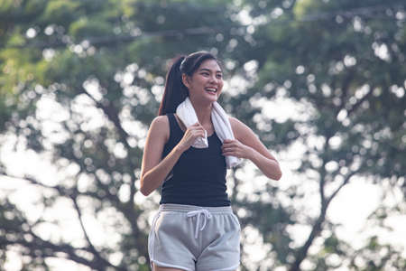 Asian woman so happy and jogging and workout foe health in the park.Sport and health concept.