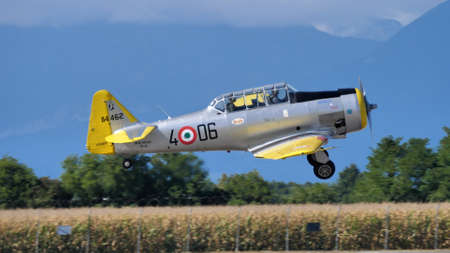Udine Italy SEPTEMBER, 17, 2021 Old military airplane of WWII landing with mountains in the background. North American T-6 Texan or Harvard ex Italian Air Forceのeditorial素材