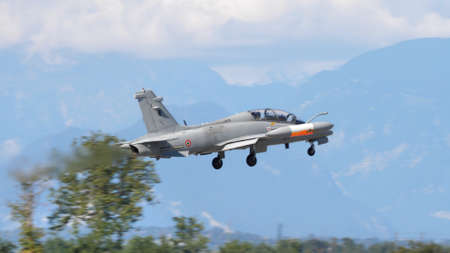 Udine, Italy SEPTEMBER, 18, 2021 Modern NATO military light jet aircraft just after take off with mountains in background and undercarriage exstracted. Aermacchi MB-339 of Italian Air Forceのeditorial素材