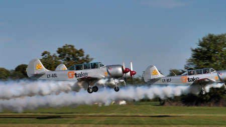 Thiene Italy OCTOBER, 16, 2021 Team of 3 soviet made acrobatic training planes take off with smoke trails. Yakovlev Yak-52 by YAK Italiaのeditorial素材