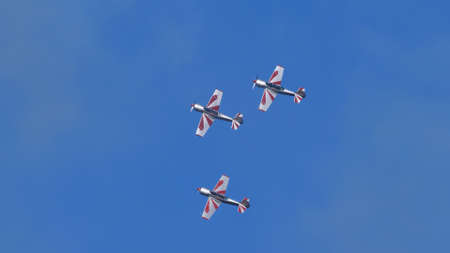 Thiene Italy OCTOBER, 16, 2021 Soviet propeller military planes in close formation in blue sky. Copy Space. Yakovlev Yak-52 by YAK Italiaのeditorial素材