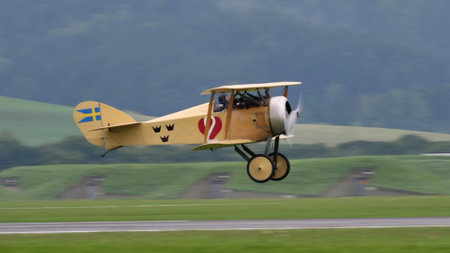 Zeltweg, Austria SEPTEMBER, 6, 2019 Vintage biplane of First World War WWI in grey heavy rain cloudy sky. FVM CVM O1 Tummelisa propeller plane of Swedish Air Force. Copy space.のeditorial素材