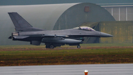 American combat aircraft on the runway, braving severe weather conditions, ready for takeoff. Copy Space. Lockheed F-16 Fighting Falcon of United States Air Force.のeditorial素材