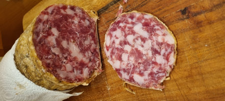 Close-up of handcrafted cured salami slices, showcasing meat textures and marbling. Vertical imageの写真素材