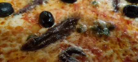 High-resolution image showcasing the details of a delicious anchovy and olive pizza toppingの写真素材