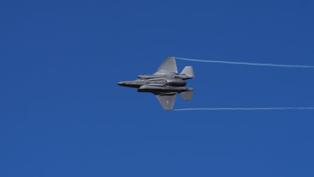 Athens Greece September 3 2023: Stealth fighter jet flying with contrails against clear blue sky. Copy Space. Lockheed Martin F-35 Lightning II of United States Air Force.のeditorial素材