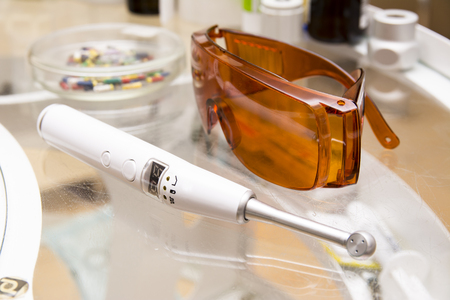 Dental tools: ultrasonic lamp and orange glases closeup imagesの写真素材