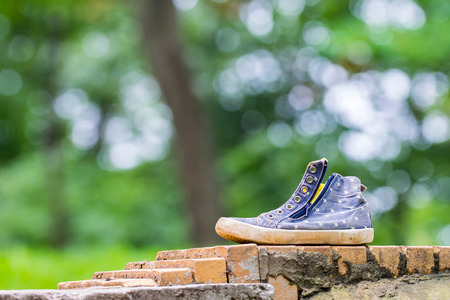 lonely abandoned shoe at the side of parkway. Green background.の写真素材