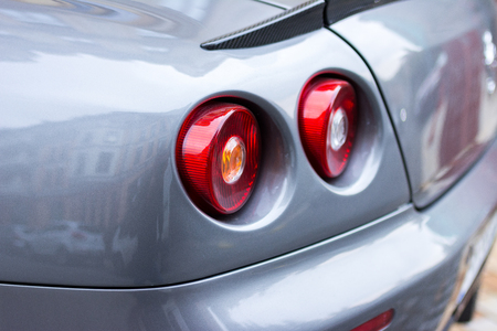 Red tail lights (rear lights, brake lights) of grey car close up image.の写真素材