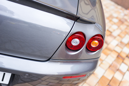 Red tail lights (rear lights, brake lights) of grey car close up image.の写真素材