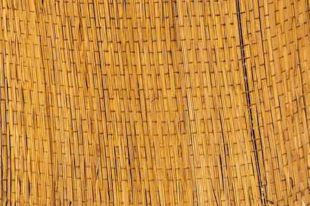 Woven straw texture. Handmade woven rug. flaxen weaving yellow mesh close up image.の写真素材