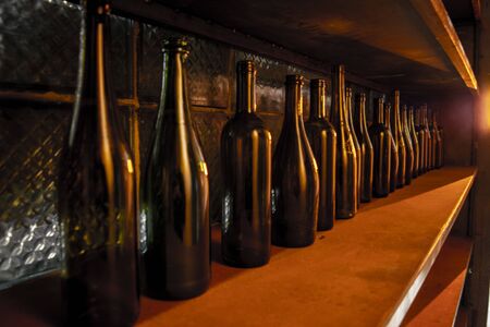 vine bottles on the wooden shelf. brown glass empty bottles.の写真素材
