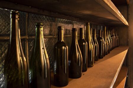 vine bottles on the wooden shelf. brown glass empty bottles.の写真素材
