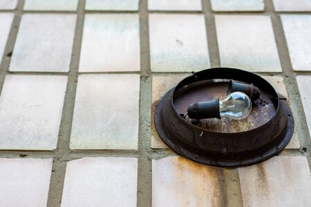 Old archaic lamp in without shade in rusted case. Rough wall light. Close up image.の写真素材