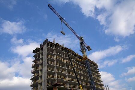 construction of a multi-storey residential building. a crane and an unfinished building on a...
