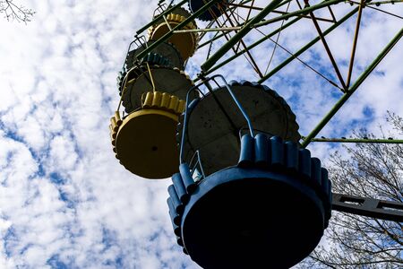 Vintage old ferris wheel in blue and yellow against the blue sky and white clouds.の写真素材