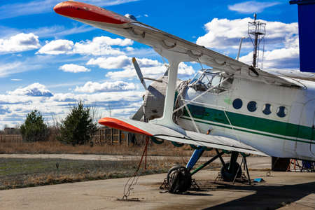 A historic biplane AN2 is parked with a sheathed engine