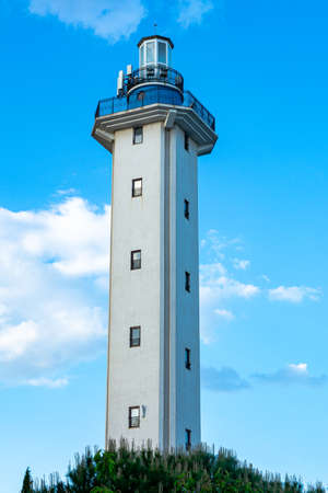 A beautiful sea lighthouse against a blue sky with clouds. Lighthouse in Bulgaria, Aheloy, vertical...