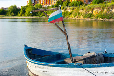 Fishing boat with the flag of Bulgaria. A white small boat of white and blue color stands on the sea surface.の写真素材