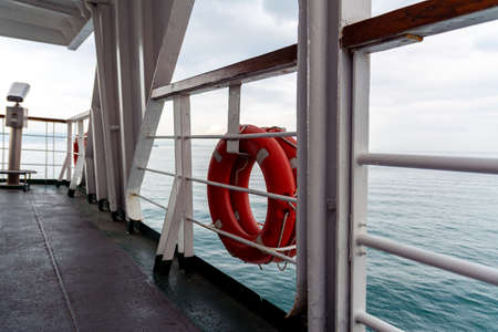 Lifebuoys hang on board a sea ferry floating on the waves.の写真素材