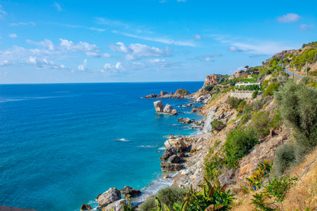 Beautiful view of the sea and rocky steep coast with banana trees. Sea panorama on a sunny summer day.の写真素材